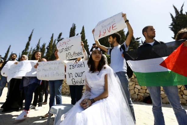 An Israeli Arab young woman wears a bridal gown as she plays the part of a bride without her groom as they pass the Rose Garden on their way to the Jerusalem offices of Israeli Prime Minister Benjamin Netanyahu